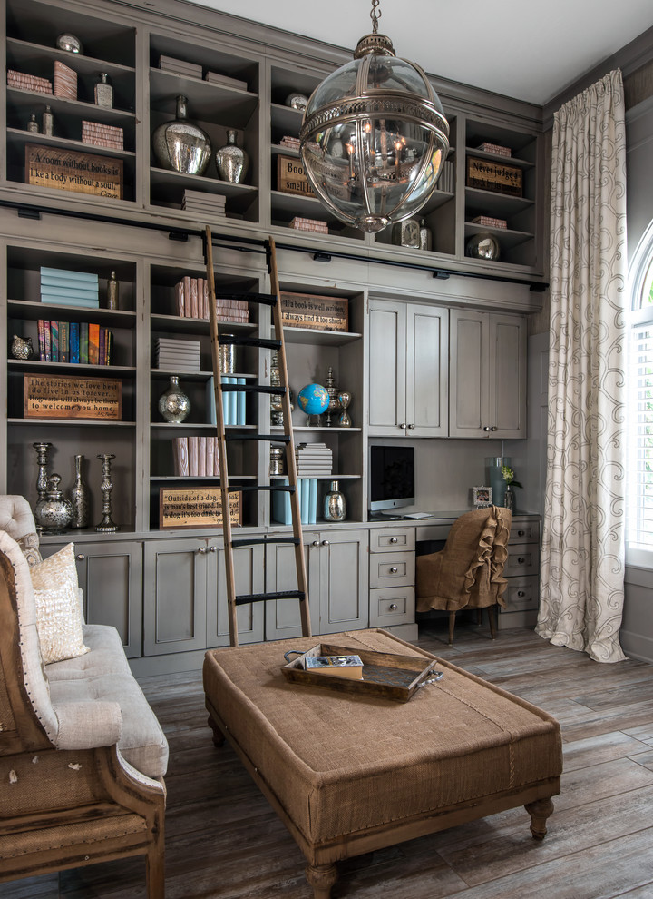 Elegant built-in desk dark wood floor home office library photo in Detroit with gray walls