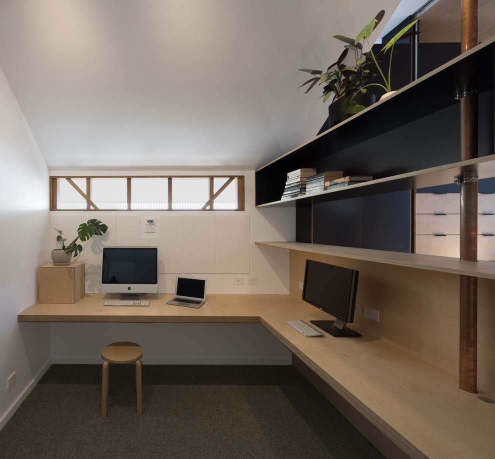 Idéer för ett litet modernt hemmabibliotek, med vita väggar, heltäckningsmatta, ett inbyggt skrivbord och grönt golv