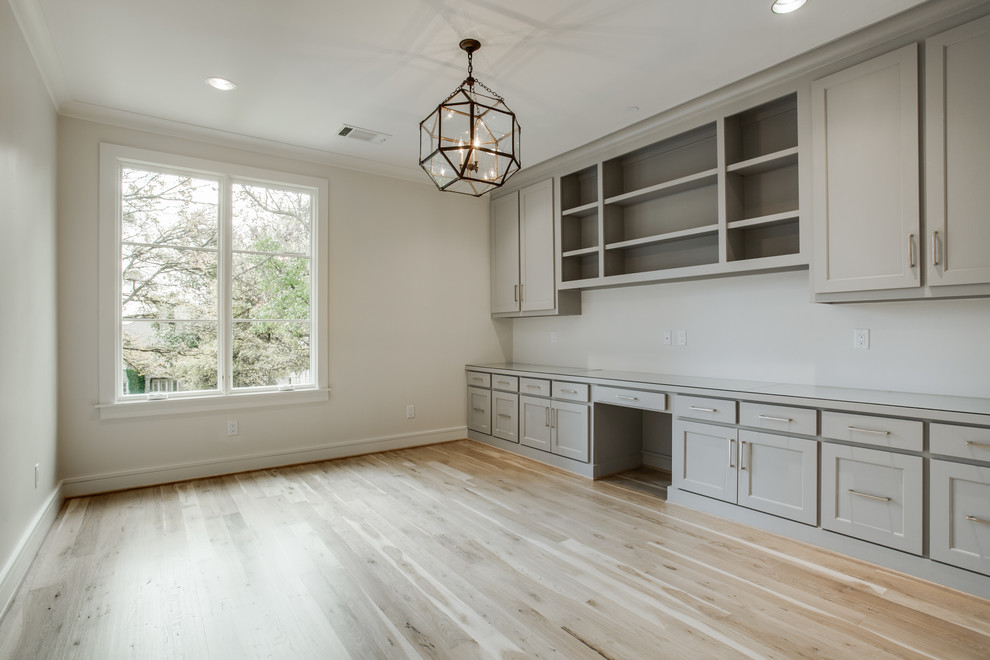Ejemplo de despacho tradicional renovado de tamaño medio con paredes blancas, suelo de madera clara y escritorio empotrado