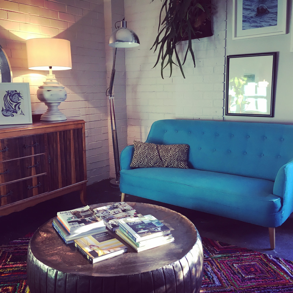 Großes Stilmix Arbeitszimmer mit Studio, blauer Wandfarbe, Betonboden, Einbau-Schreibtisch und schwarzem Boden in Melbourne