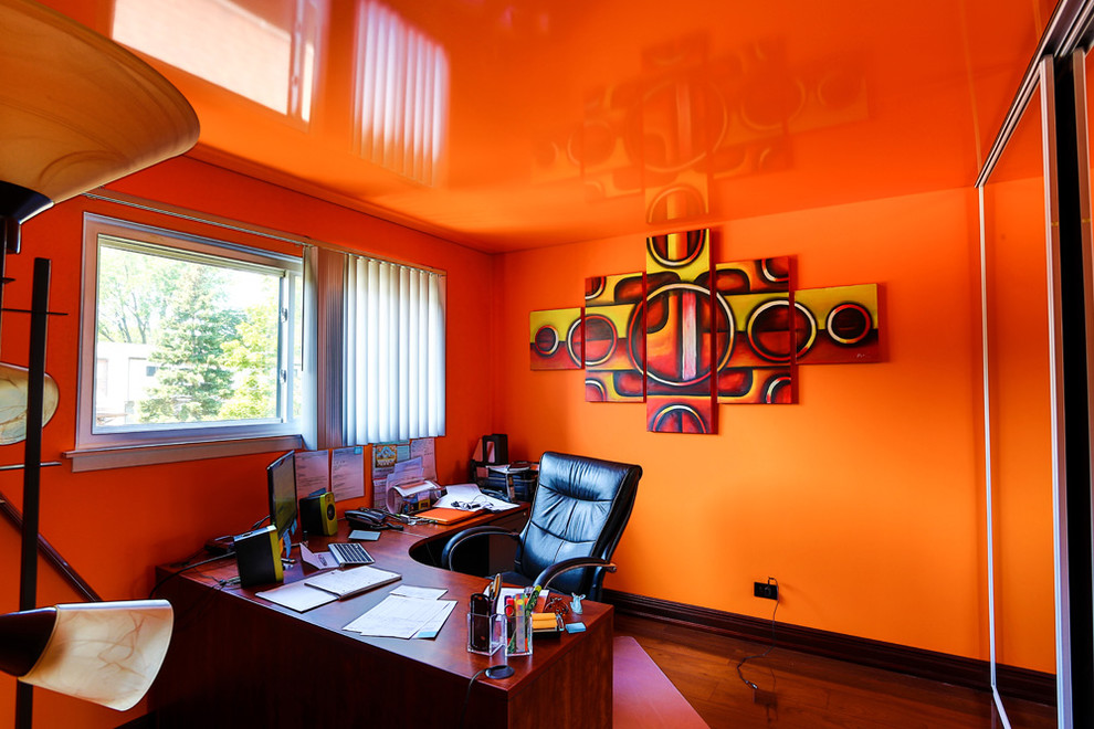 Cette image montre un bureau design avec un mur orange.