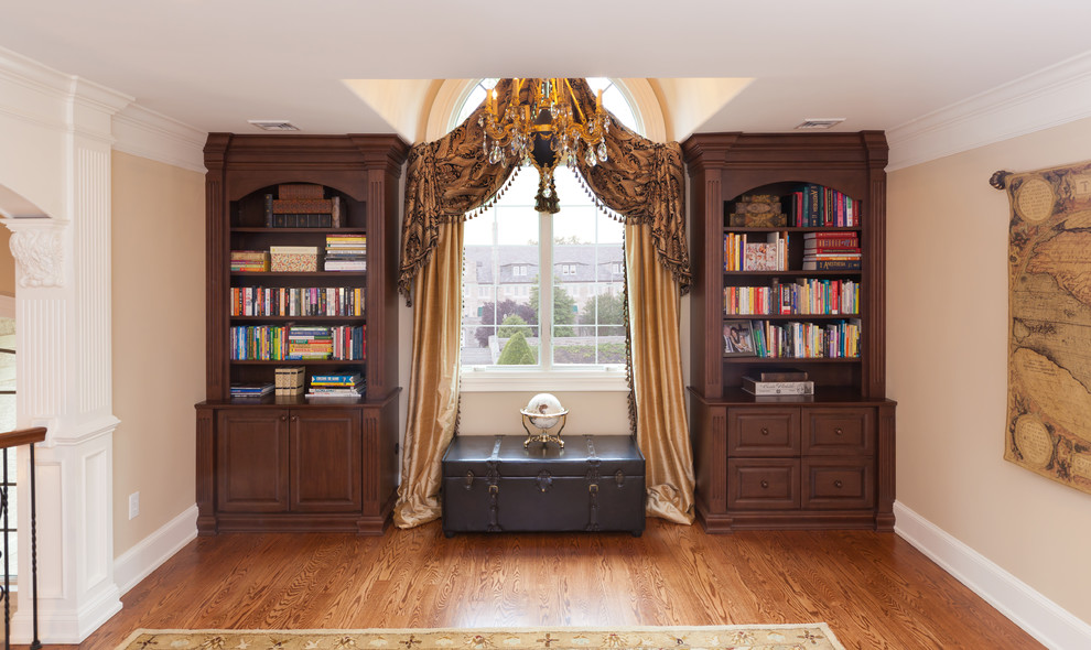 Imagen de despacho tradicional de tamaño medio con paredes beige y suelo de madera en tonos medios