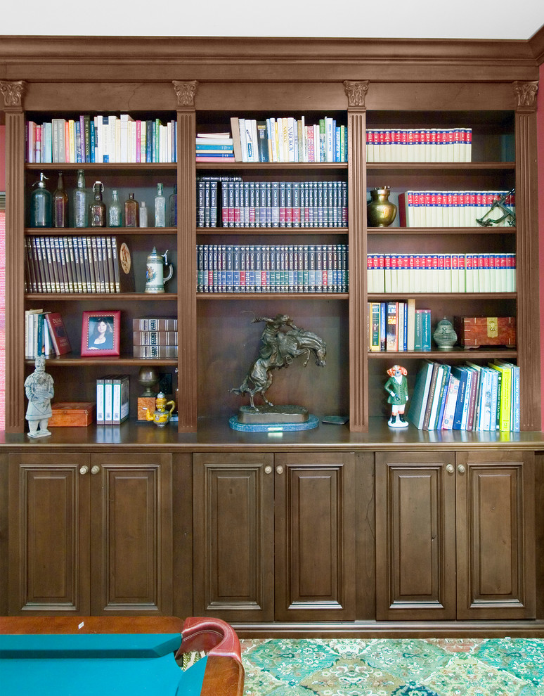 Foto på ett mellanstort vintage hemmabibliotek, med vita väggar, mörkt trägolv, ett fristående skrivbord och brunt golv