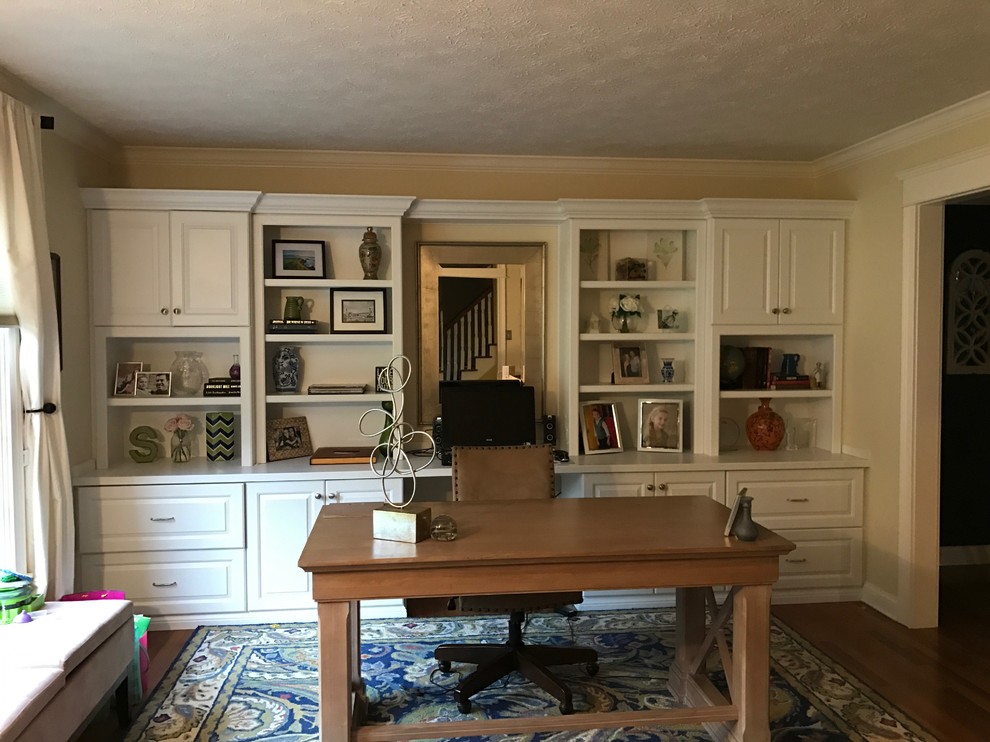 Imagen de despacho clásico renovado grande sin chimenea con paredes beige, suelo de madera en tonos medios y escritorio independiente