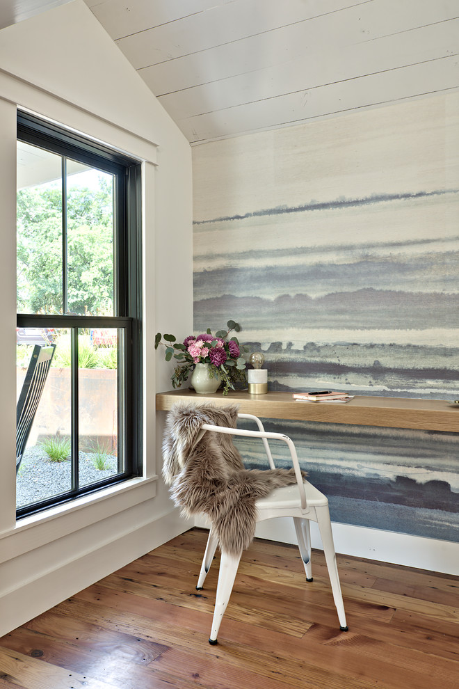 Ejemplo de despacho campestre con paredes multicolor, suelo de madera en tonos medios y escritorio empotrado