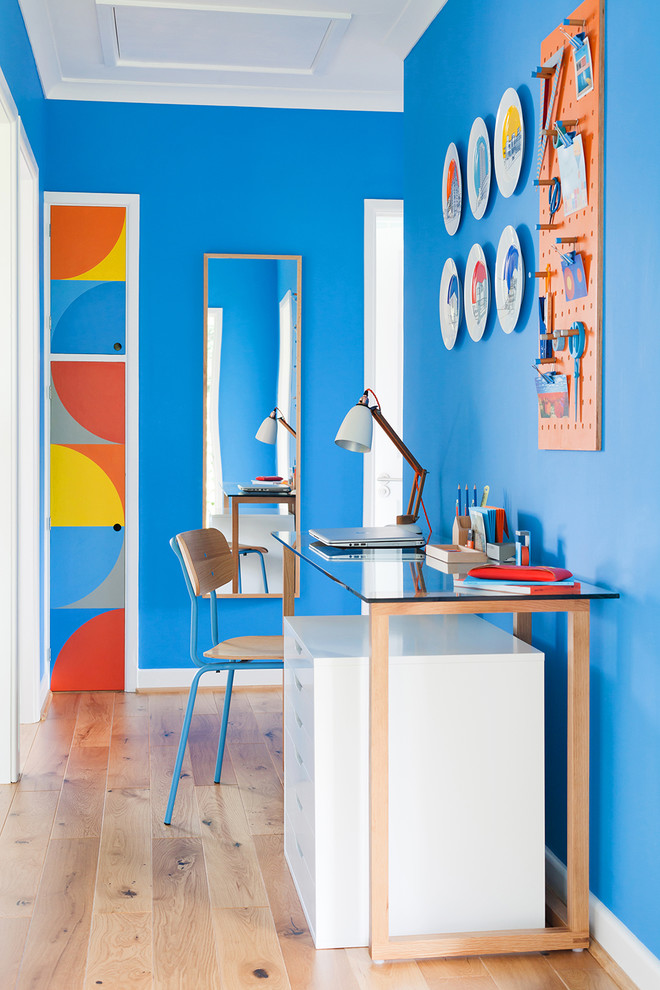 ケンブリッジシャーにある小さなコンテンポラリースタイルのおしゃれな書斎 (青い壁、淡色無垢フローリング、暖炉なし、自立型机) の写真