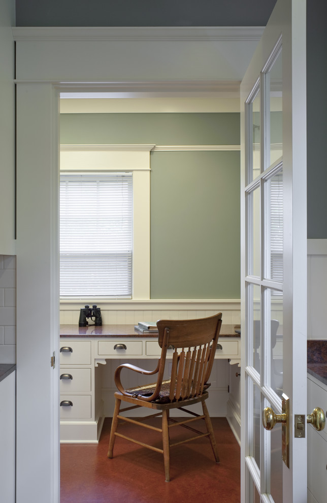 Inredning av ett amerikanskt mellanstort arbetsrum, med gröna väggar, linoleumgolv och ett inbyggt skrivbord