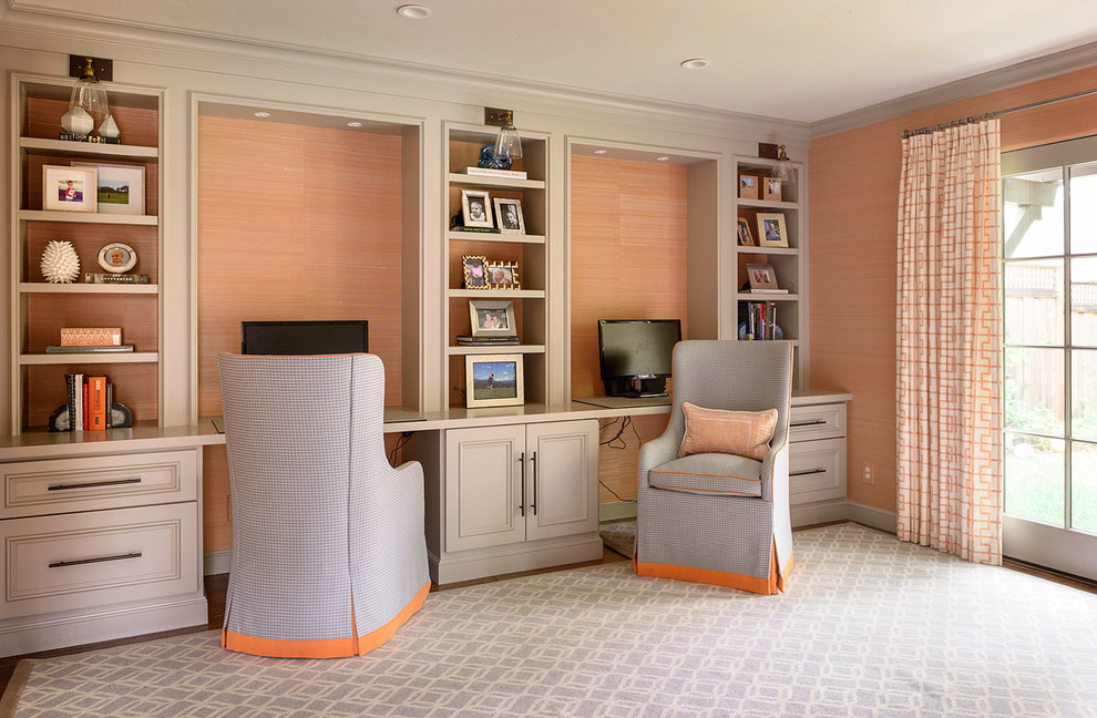 Diseño de despacho clásico renovado grande sin chimenea con parades naranjas, suelo de madera en tonos medios y escritorio empotrado