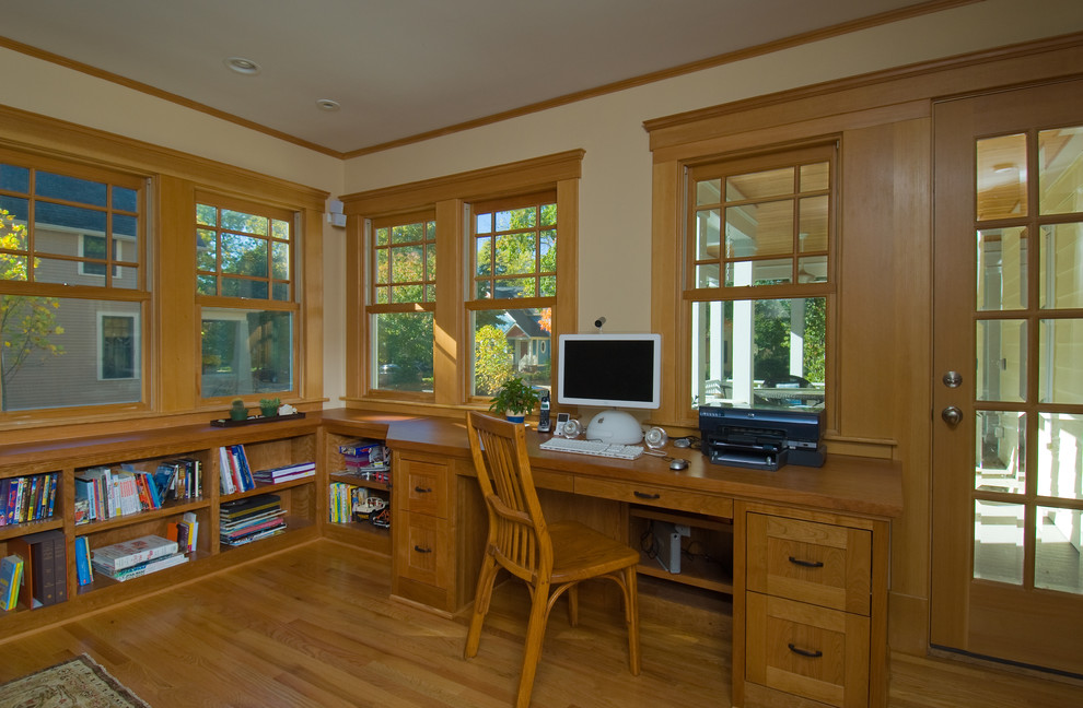 Mittelgroßes Klassisches Arbeitszimmer mit Einbau-Schreibtisch, Arbeitsplatz, beiger Wandfarbe und braunem Holzboden in Detroit