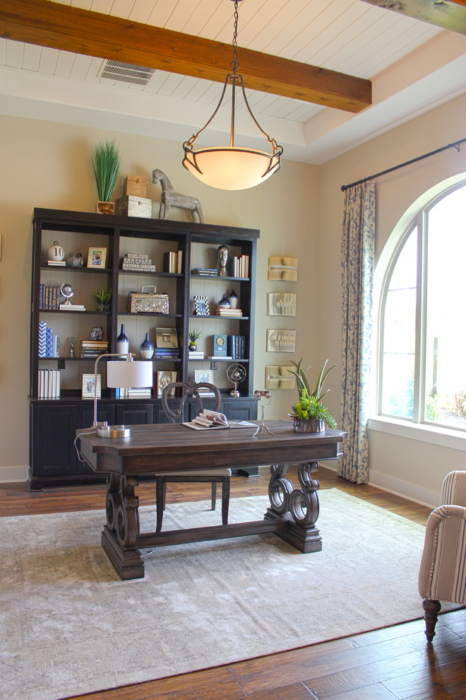 Imagen de despacho tradicional renovado de tamaño medio con paredes beige, suelo de madera en tonos medios y escritorio independiente