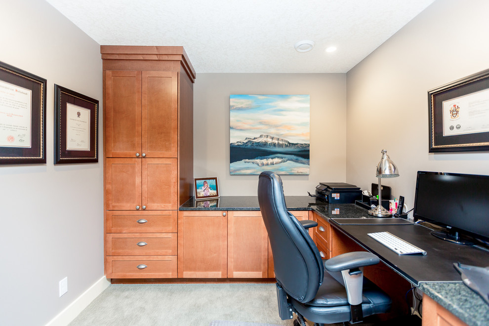 Example of a mid-sized classic built-in desk carpeted home office library design in Calgary with beige walls and no fireplace