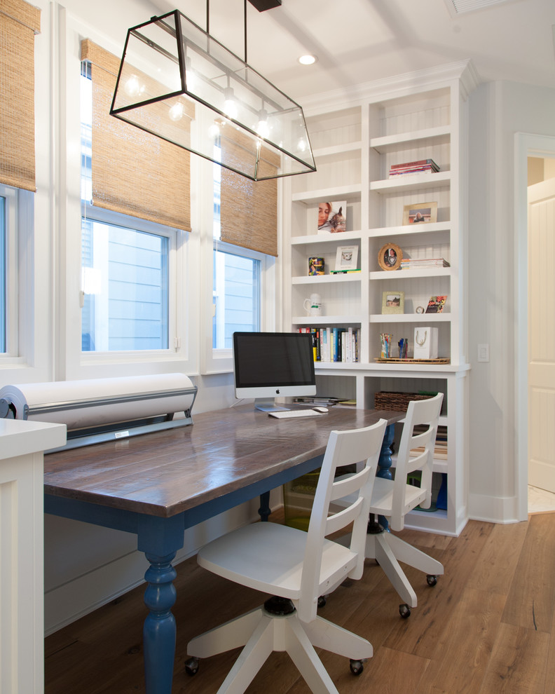 Idee per uno studio costiero con pareti bianche, pavimento in legno massello medio e scrivania autoportante