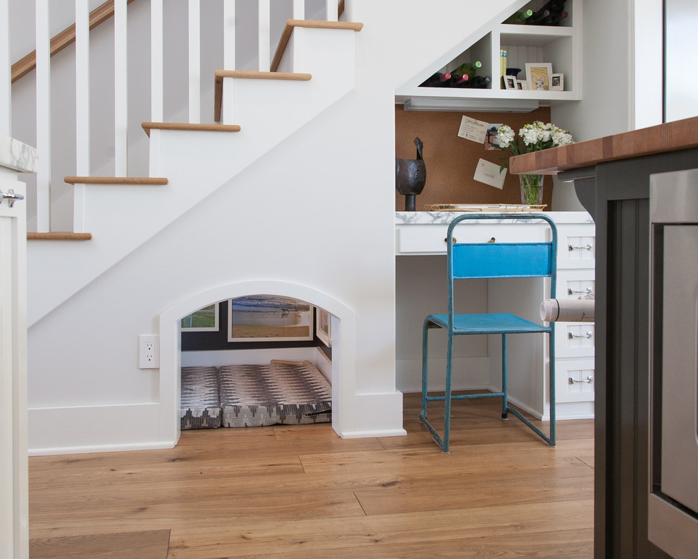Example of a beach style medium tone wood floor home office design in Orange County with white walls