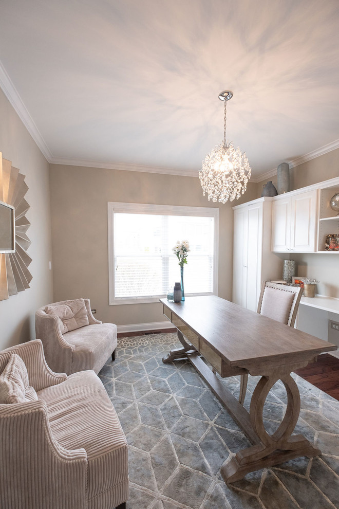 Foto de despacho clásico renovado de tamaño medio sin chimenea con paredes beige, suelo vinílico, escritorio independiente y suelo marrón