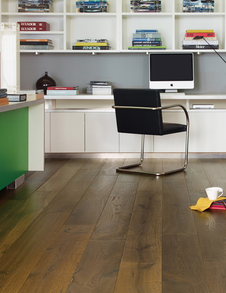 Réalisation d'un bureau atelier tradition de taille moyenne avec un sol en bois brun, un bureau intégré et un mur gris.