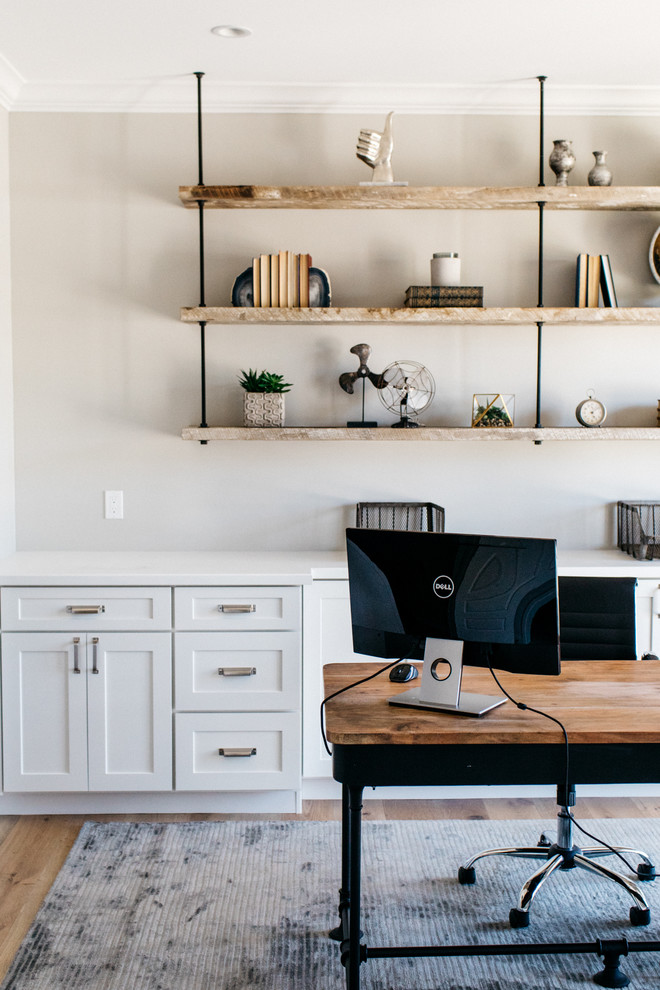 На фото: кабинет в стиле кантри с серыми стенами, светлым паркетным полом и отдельно стоящим рабочим столом без камина с