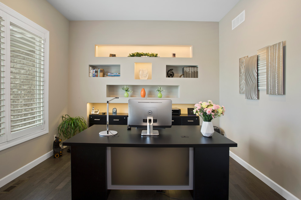 Foto de despacho minimalista de tamaño medio con paredes grises, suelo de madera en tonos medios y escritorio independiente