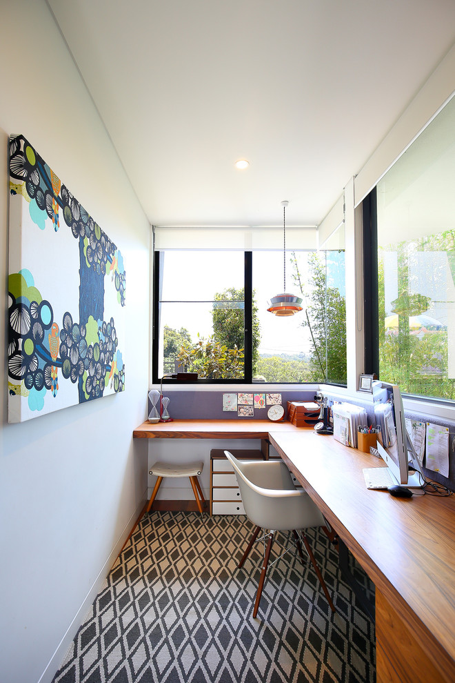 Modernes Arbeitszimmer mit Arbeitsplatz, weißer Wandfarbe, Teppichboden und Einbau-Schreibtisch in Sydney