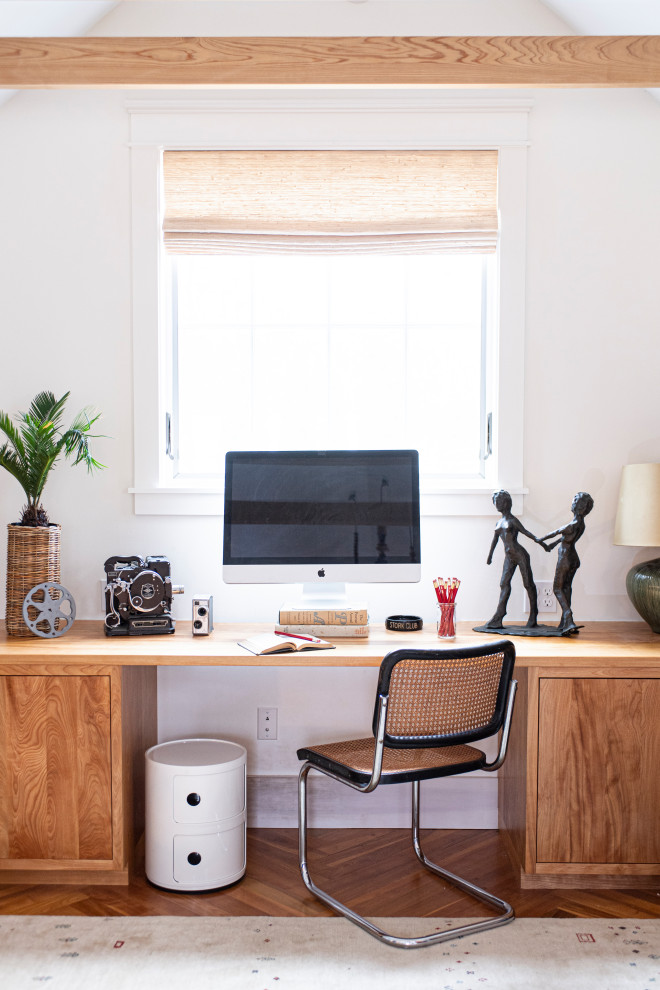 Exempel på ett modernt arbetsrum, med vita väggar, mellanmörkt trägolv, ett inbyggt skrivbord och brunt golv