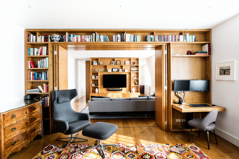 Mittelgroßes Modernes Arbeitszimmer ohne Kamin mit weißer Wandfarbe und braunem Holzboden in London