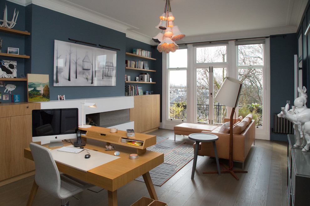 На фото: кабинет в современном стиле с синими стенами, паркетным полом среднего тона, стандартным камином, отдельно стоящим рабочим столом и коричневым полом с