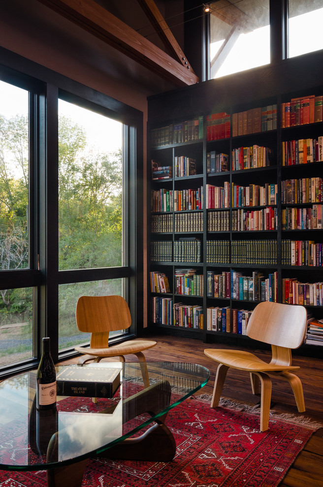 Idéer för ett mellanstort modernt hemmabibliotek, med mellanmörkt trägolv, ett fristående skrivbord och bruna väggar