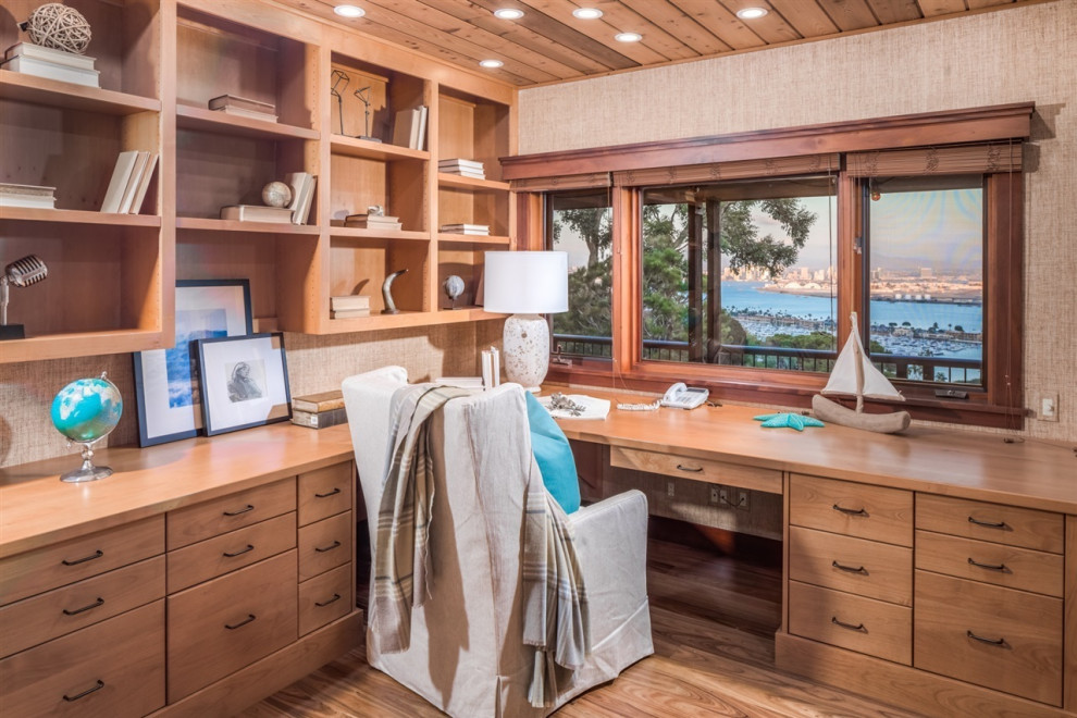Maritimes Arbeitszimmer mit beiger Wandfarbe, braunem Holzboden, Einbau-Schreibtisch und braunem Boden in San Diego