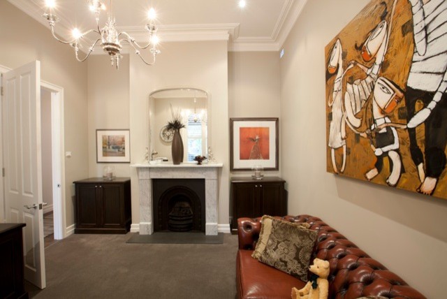 メルボルンにある高級な広いヴィクトリアン調のおしゃれな書斎 (グレーの壁、カーペット敷き、標準型暖炉、石材の暖炉まわり、自立型机) の写真