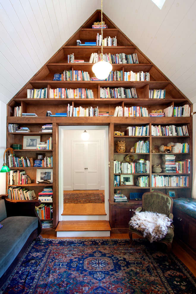 Inspiration för ett mellanstort lantligt hemmabibliotek, med vita väggar och mellanmörkt trägolv