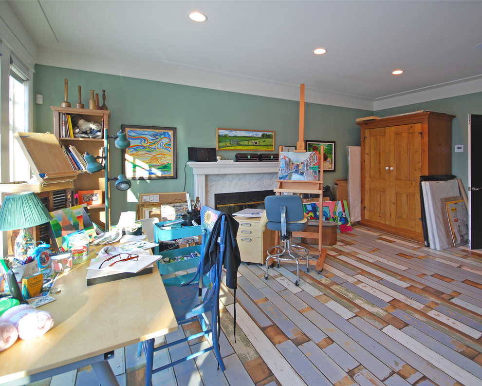 Craft room - large transitional freestanding desk painted wood floor craft room idea in Edmonton with green walls, a standard fireplace and a stone fireplace