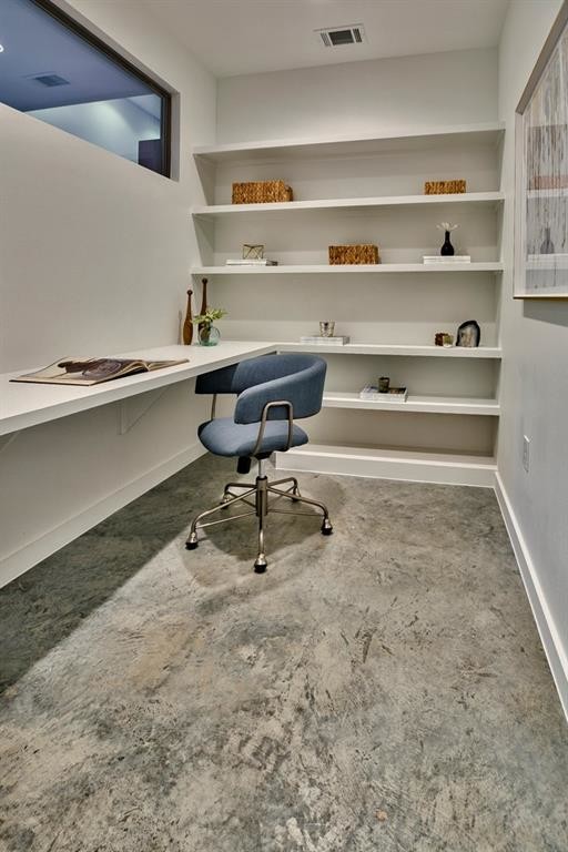 На фото: кабинет среднего размера в современном стиле с серыми стенами, бетонным полом, встроенным рабочим столом и серым полом без камина
