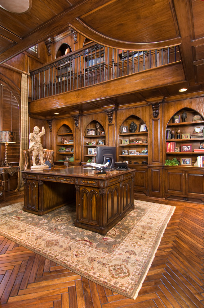 Inspiration för stora medelhavsstil hemmabibliotek, med mellanmörkt trägolv och ett fristående skrivbord
