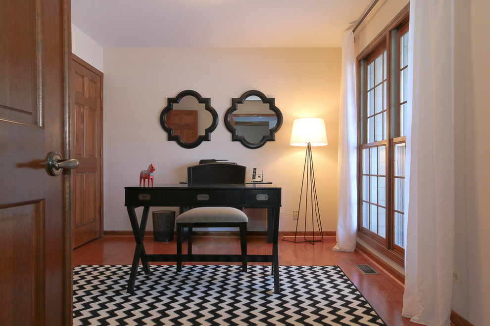 Mittelgroßes Klassisches Arbeitszimmer mit beiger Wandfarbe, braunem Holzboden und freistehendem Schreibtisch in Chicago