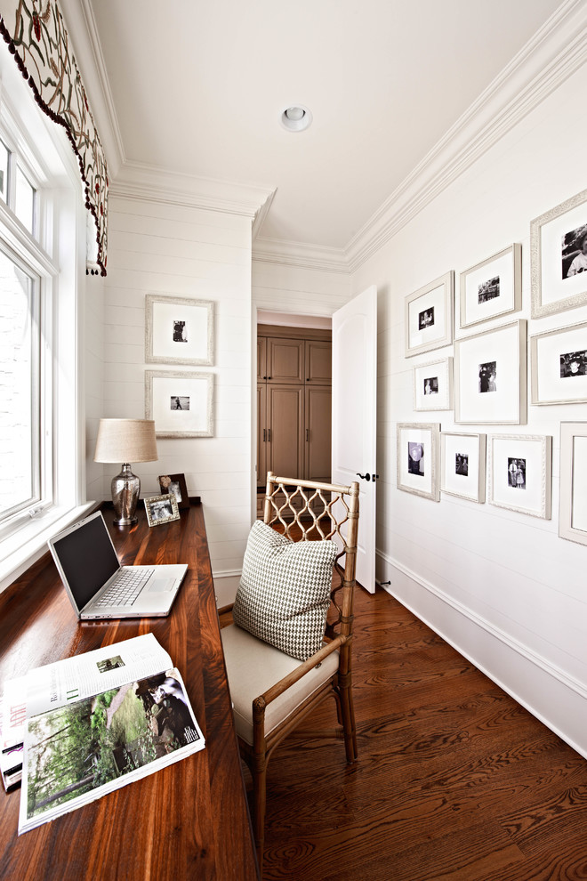 Imagen de despacho tradicional con paredes blancas, suelo de madera oscura y escritorio empotrado