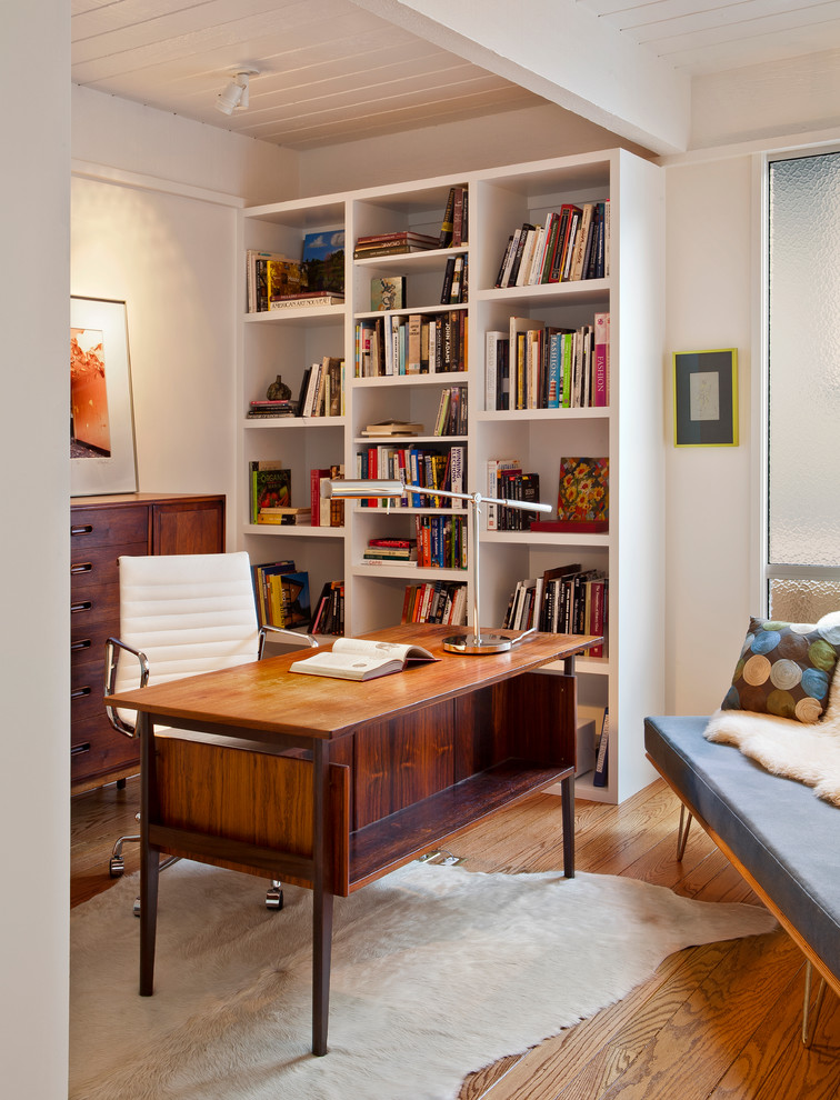 Réalisation d'un bureau vintage avec un mur blanc, un sol en bois brun et un bureau indépendant.