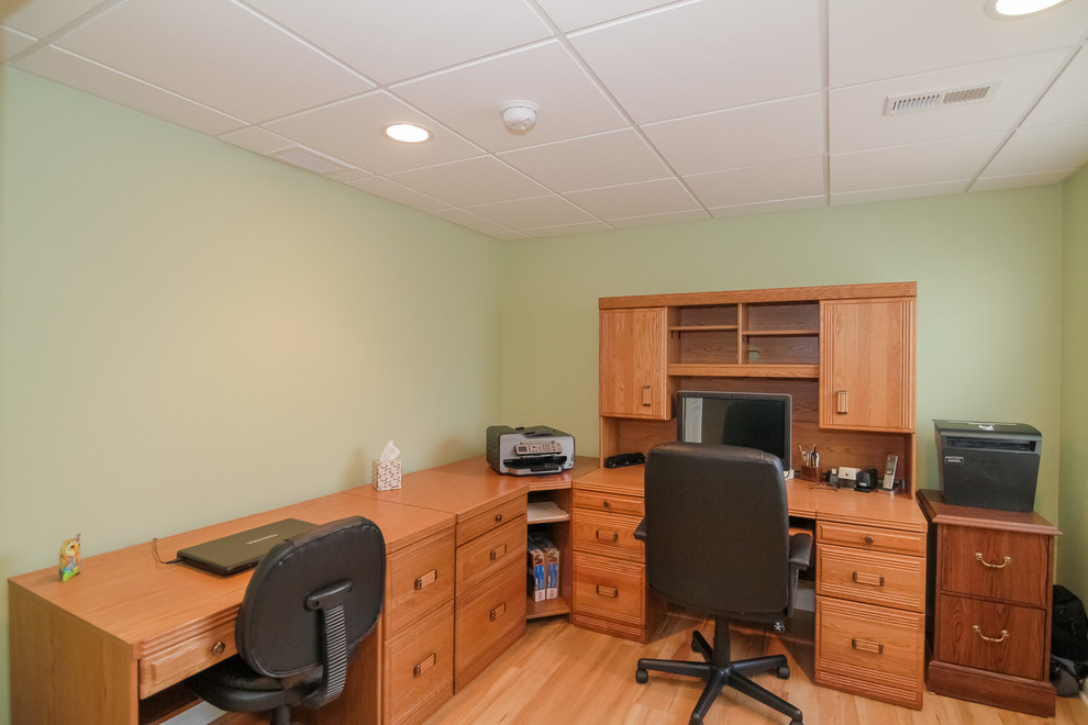 Ispirazione per un ufficio moderno di medie dimensioni con pareti verdi, parquet chiaro, nessun camino, scrivania autoportante e pavimento beige