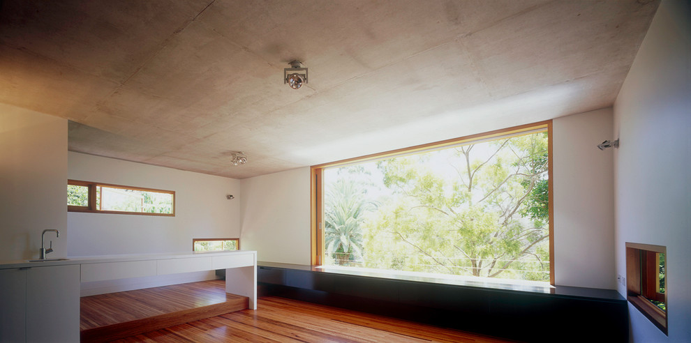 Esempio di un atelier minimal di medie dimensioni con pareti bianche, pavimento in legno massello medio e scrivania incassata