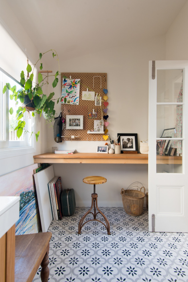 Идея дизайна: домашняя мастерская среднего размера в скандинавском стиле с белыми стенами, полом из керамической плитки, встроенным рабочим столом и разноцветным полом без камина