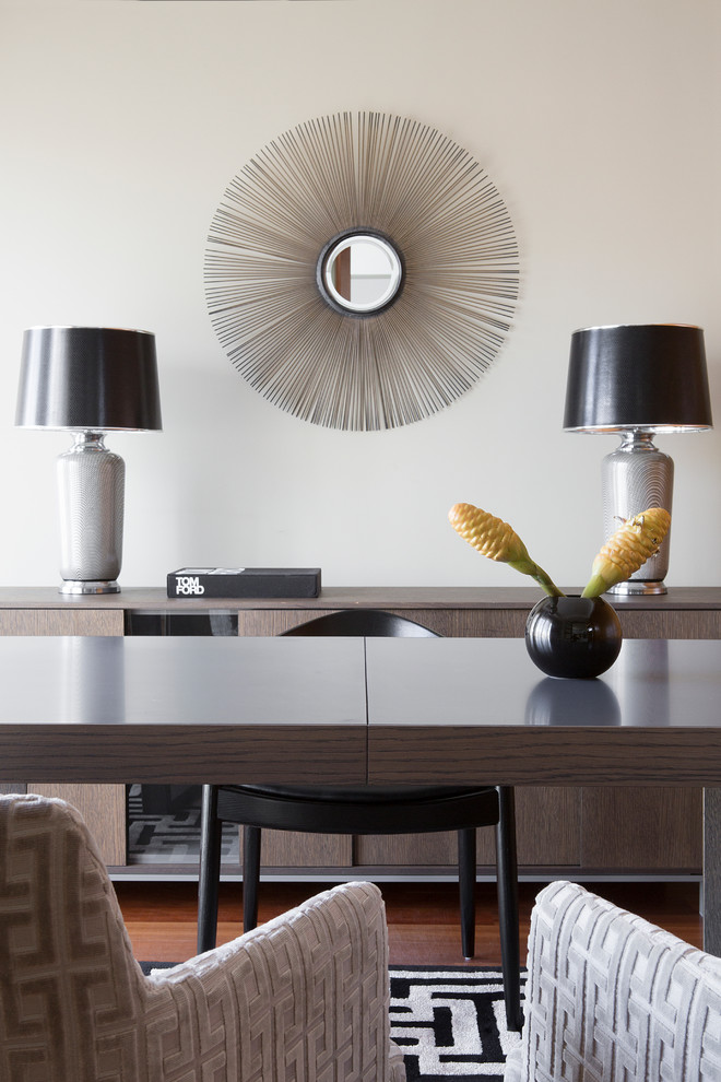 Ejemplo de despacho contemporáneo de tamaño medio con paredes beige, suelo de madera en tonos medios y escritorio independiente