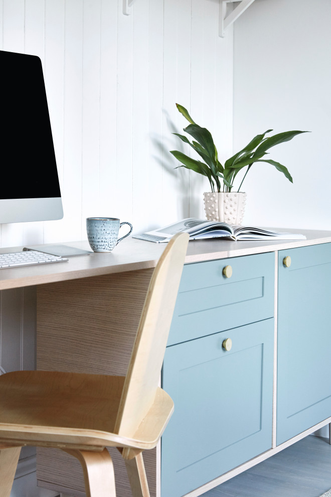 Ejemplo de despacho minimalista de tamaño medio con paredes blancas y escritorio empotrado