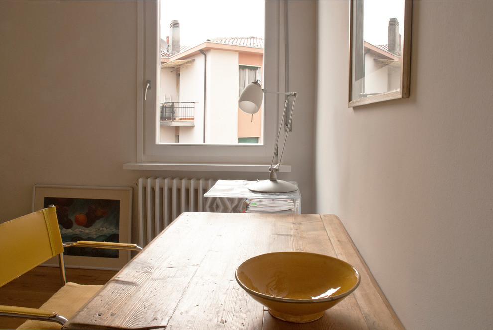 Esempio di un piccolo atelier minimalista con pareti bianche, pavimento in legno massello medio e scrivania autoportante