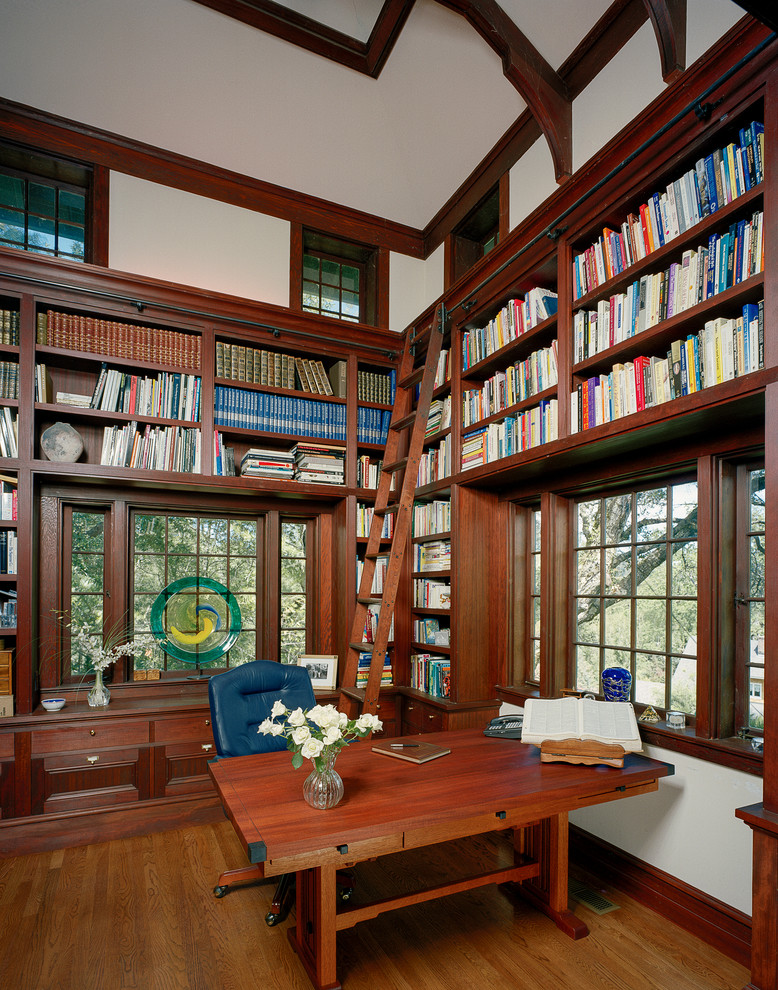 Пример оригинального дизайна: домашняя библиотека в классическом стиле с бежевыми стенами, паркетным полом среднего тона и отдельно стоящим рабочим столом