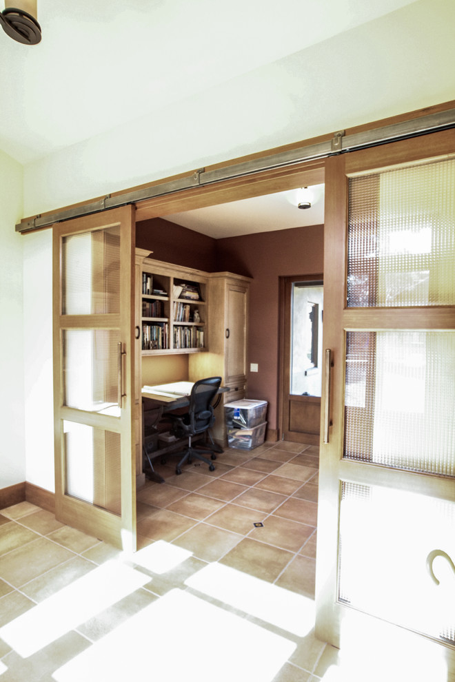 Ejemplo de despacho mediterráneo de tamaño medio con paredes beige, suelo de travertino, escritorio independiente y suelo beige