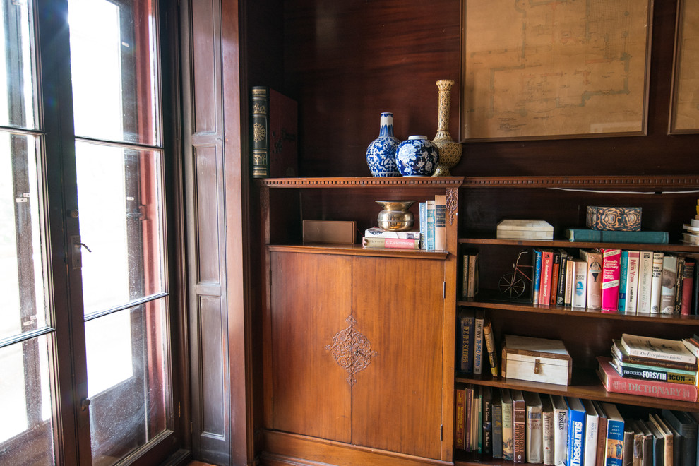 This is an example of a medium sized victorian study in New York with brown walls, light hardwood flooring, no fireplace, a freestanding desk and brown floors.