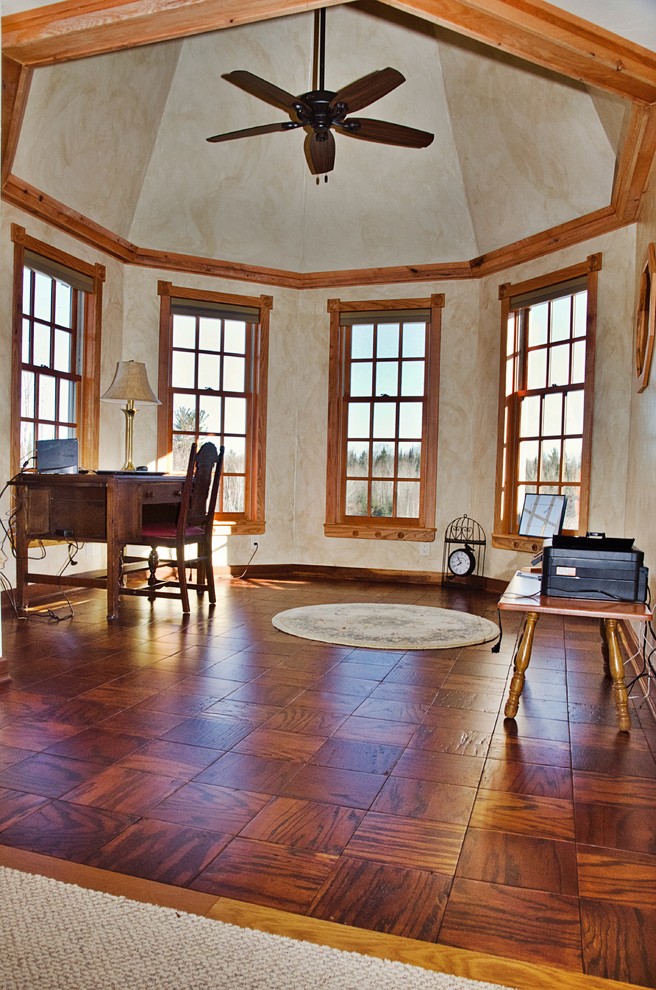 Idéer för ett mellanstort rustikt hemmabibliotek, med beige väggar, mellanmörkt trägolv, ett fristående skrivbord och brunt golv