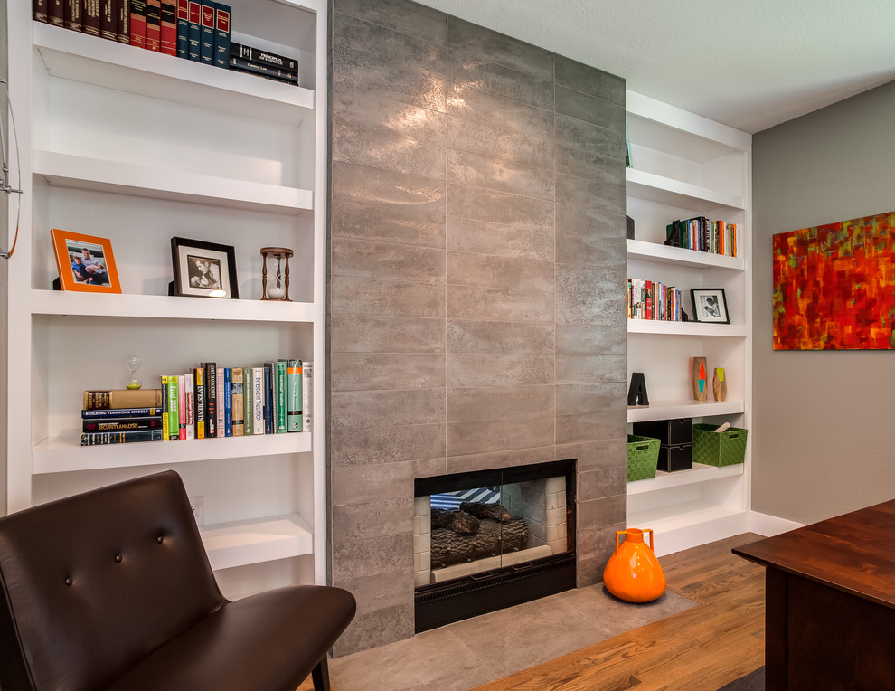 Mittelgroßes Modernes Arbeitszimmer mit Arbeitsplatz, beiger Wandfarbe, braunem Holzboden, Kamin, freistehendem Schreibtisch und gefliester Kaminumrandung in Denver