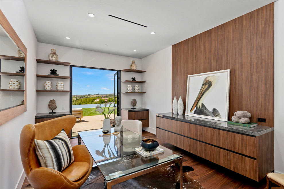 Trendy freestanding desk dark wood floor and brown floor home office photo in San Diego with white walls