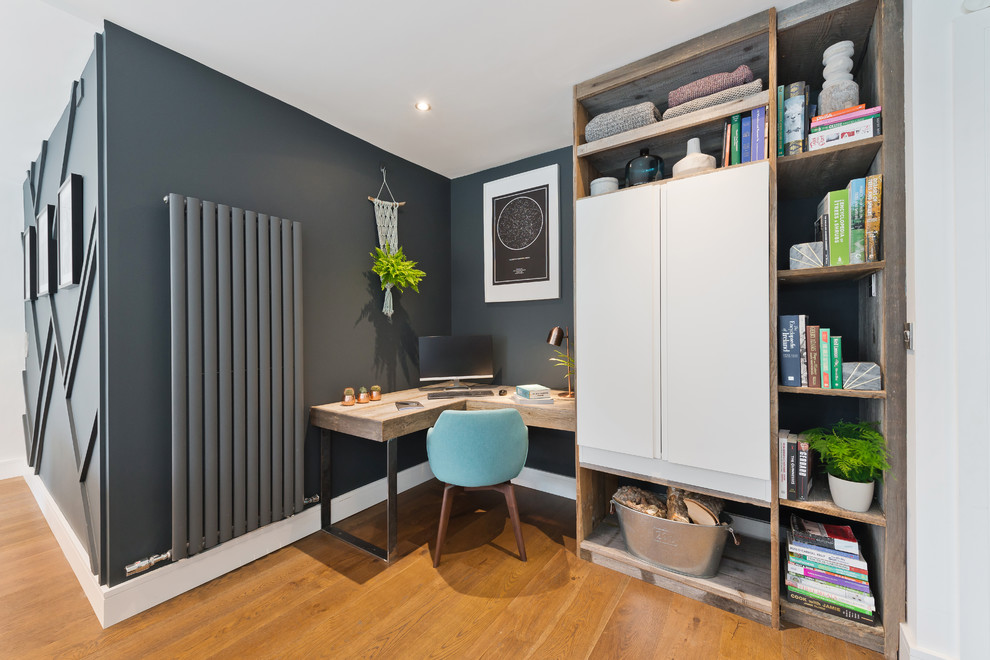 На фото: кабинет в современном стиле с серыми стенами, паркетным полом среднего тона, отдельно стоящим рабочим столом и коричневым полом