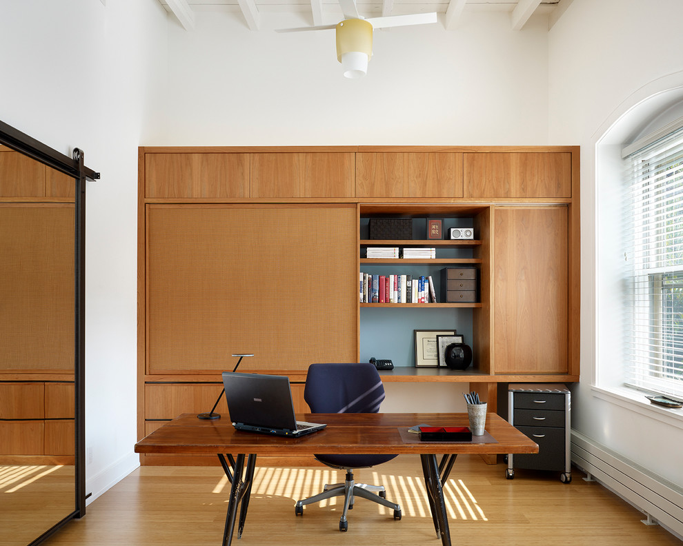 This is an example of a modern home office in Philadelphia with white walls.