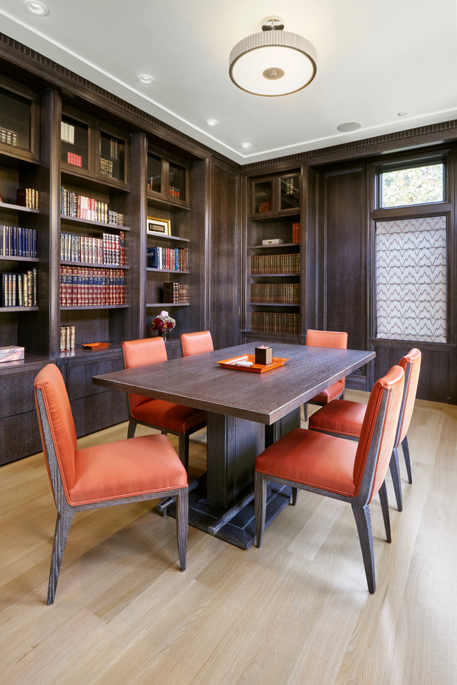 Пример оригинального дизайна: домашняя библиотека среднего размера в стиле неоклассика (современная классика) с коричневыми стенами, светлым паркетным полом и отдельно стоящим рабочим столом